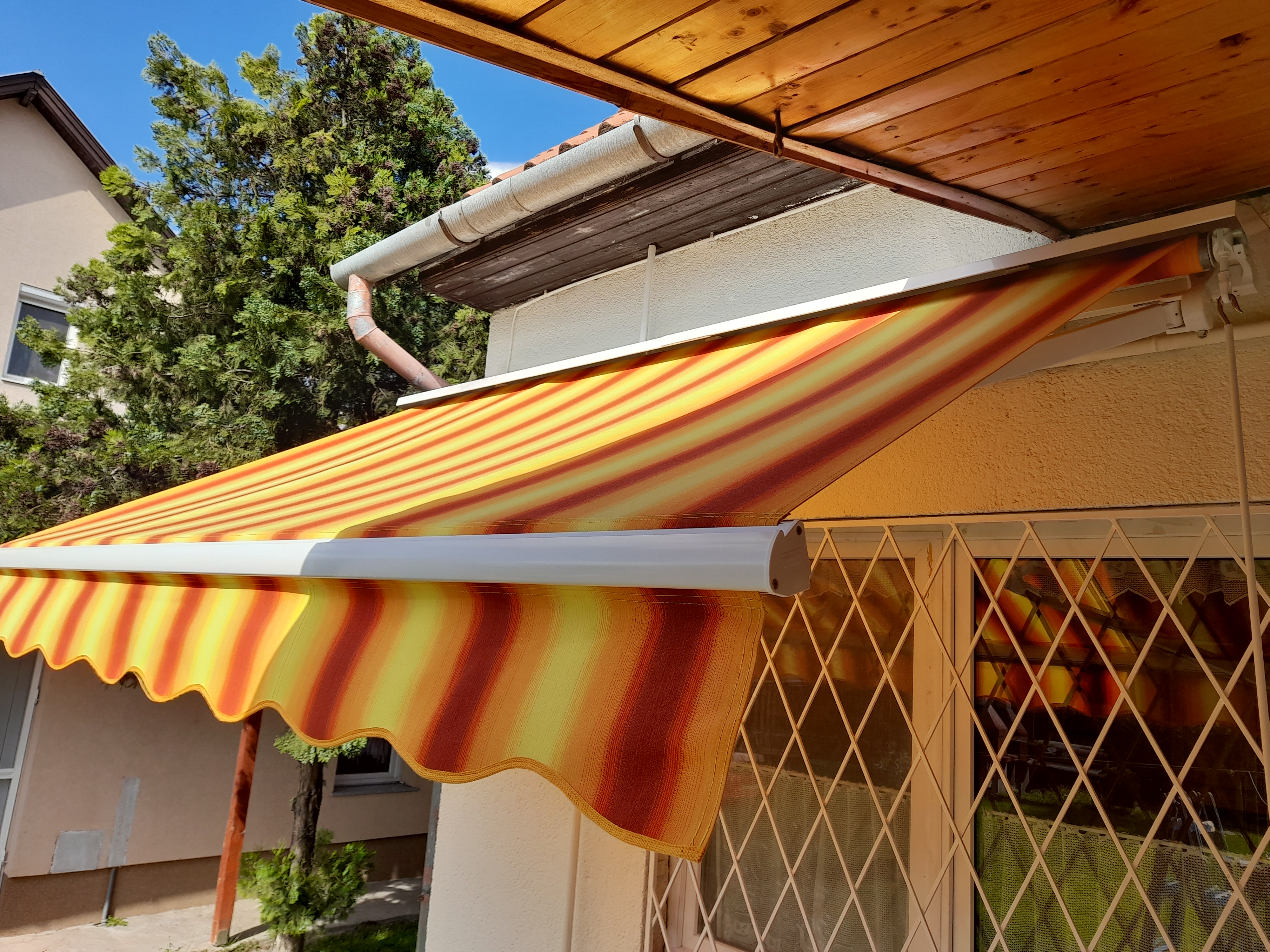 Zártszelvényes csuklókaros napellenző terasz